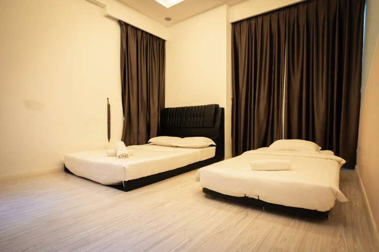 Cozy Suites twin accommodation featuring black bed frames, warm wood floors and natural ceiling light