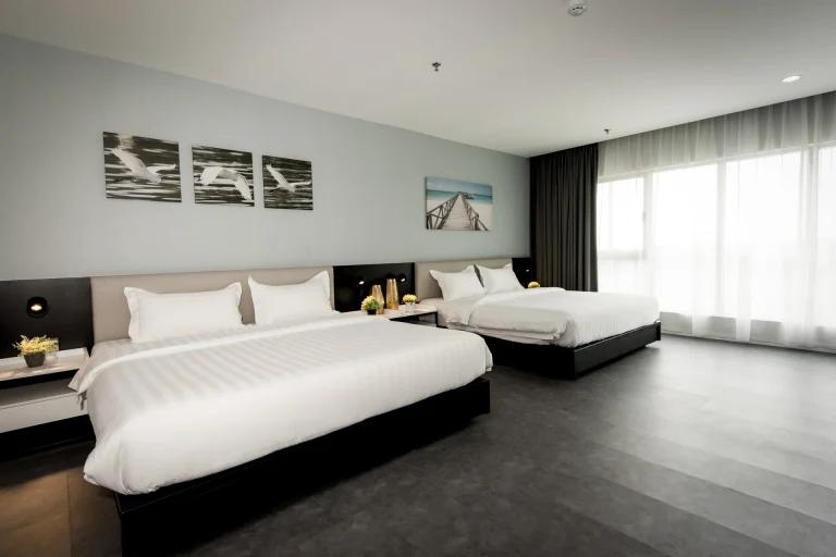 Twin bedroom at Inkk Hotel Family room showing separate king beds, wall art, and contemporary furnishings