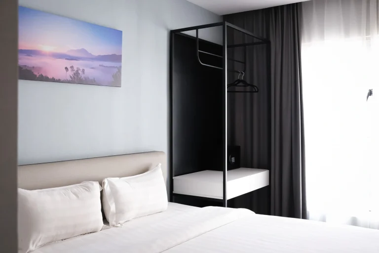Hotel room detail showing Inkk Hotel with King bed setup, landscape painting, and modern furniture design