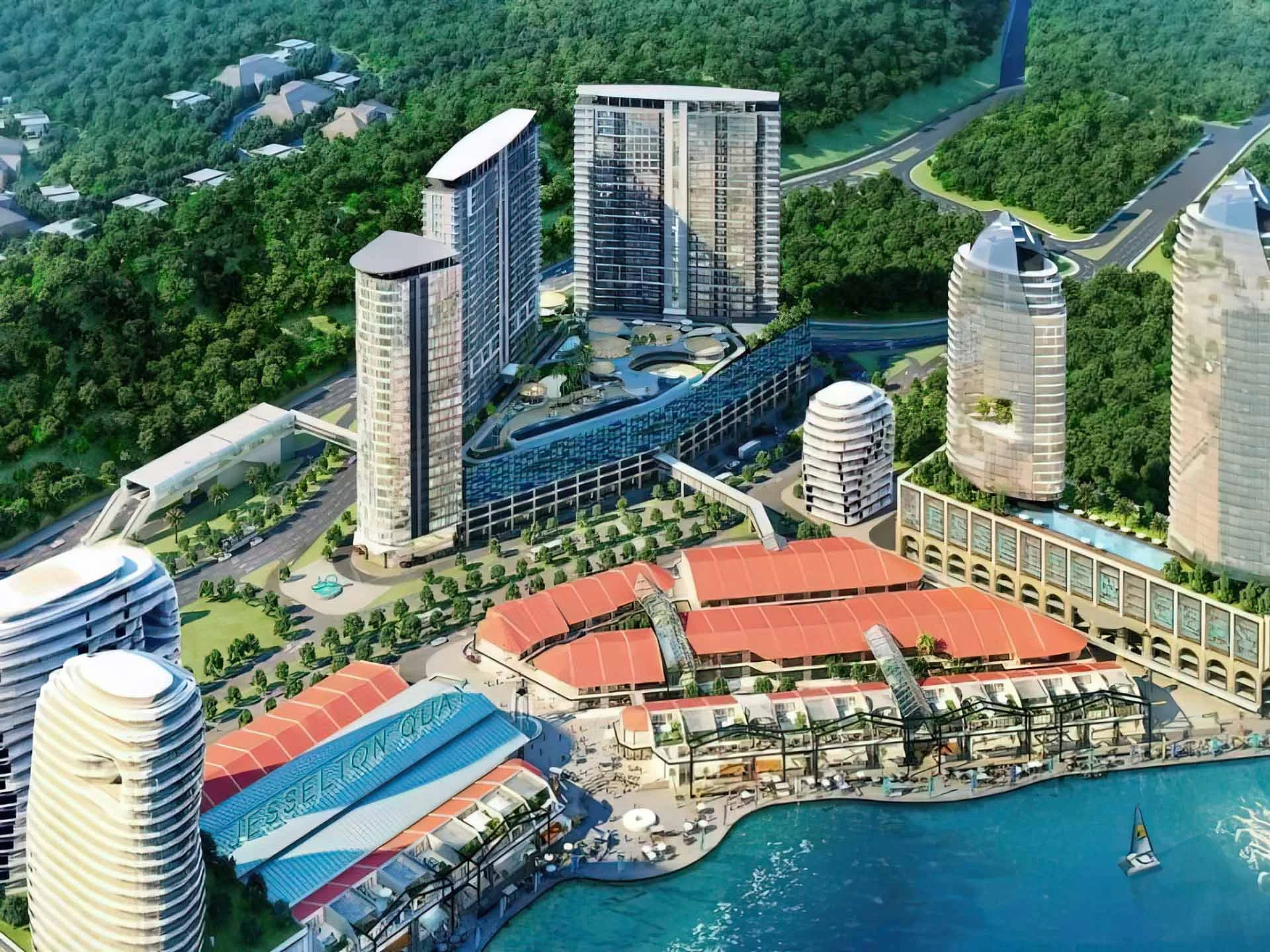 Aerial view of waterfront development featuring high-rise towers, marina, and colorful retail complex at Jesselton Quay